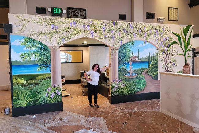 Hayley Ferreira in a hallway where she pained a mural